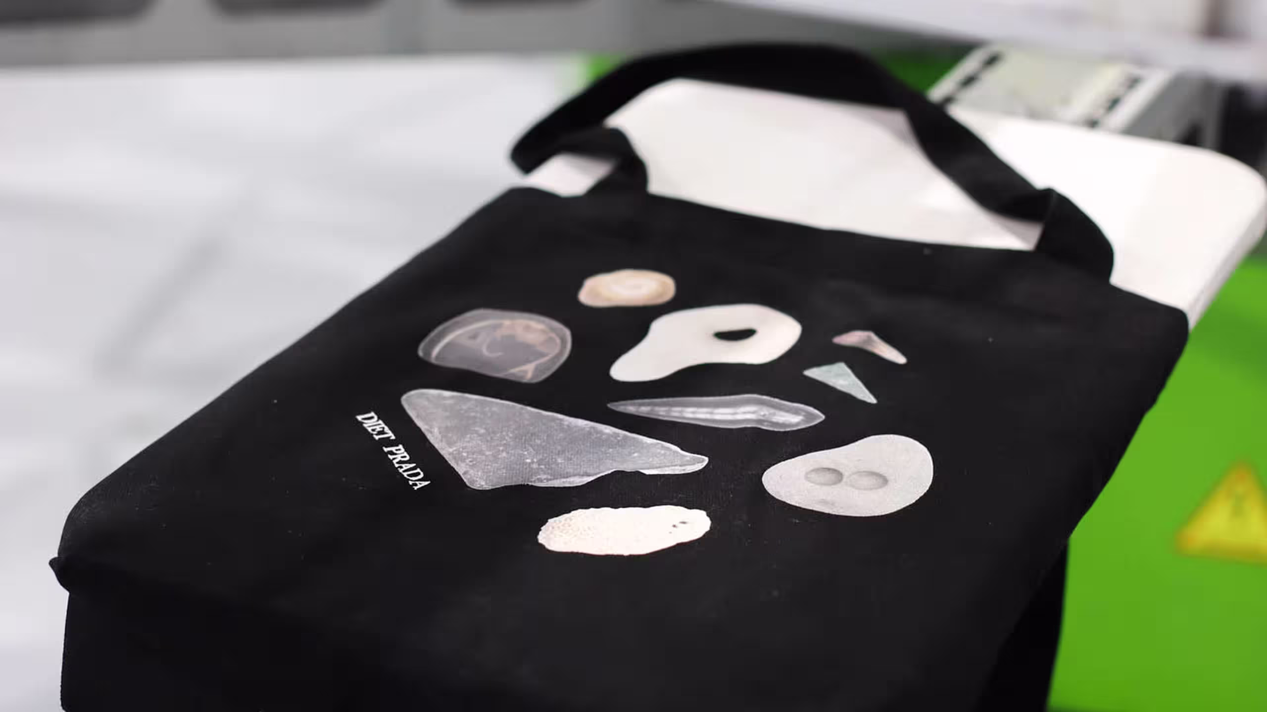 close up of a black tote bag laying on a screen printer pallet