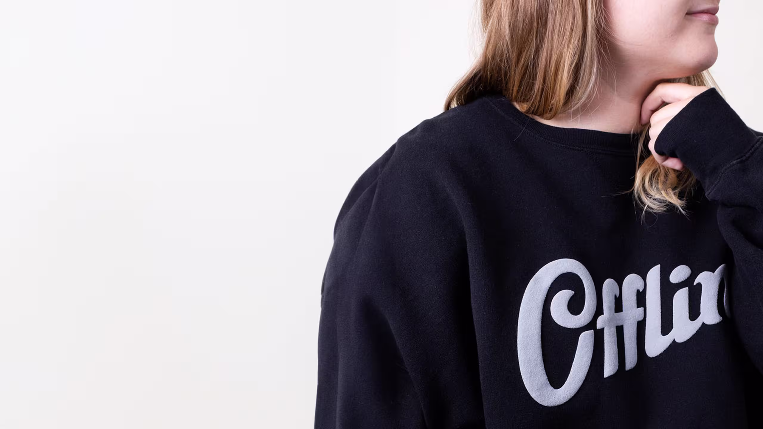 women wearing a black crewneck sweatshirt with white text printed in puff print