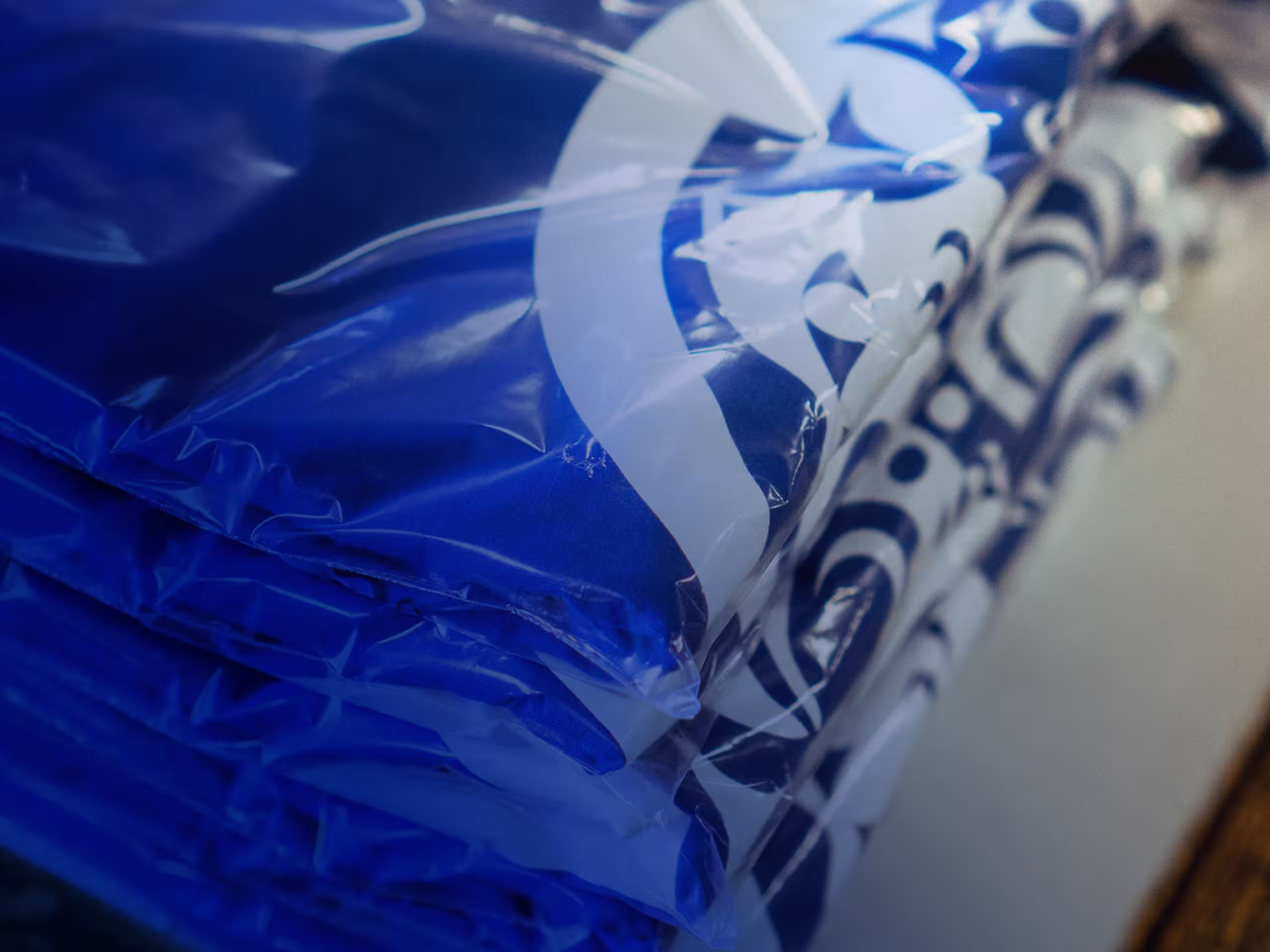 a stack of folded and bagged blue t-shirts