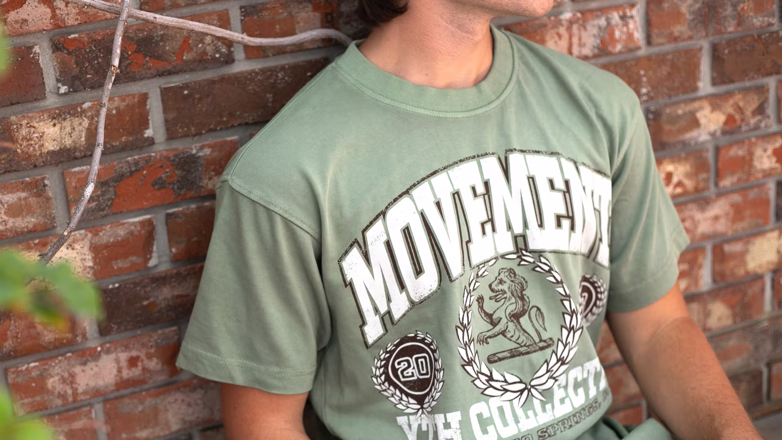 man wearing a green t-shirt with the word movement printed large on the front