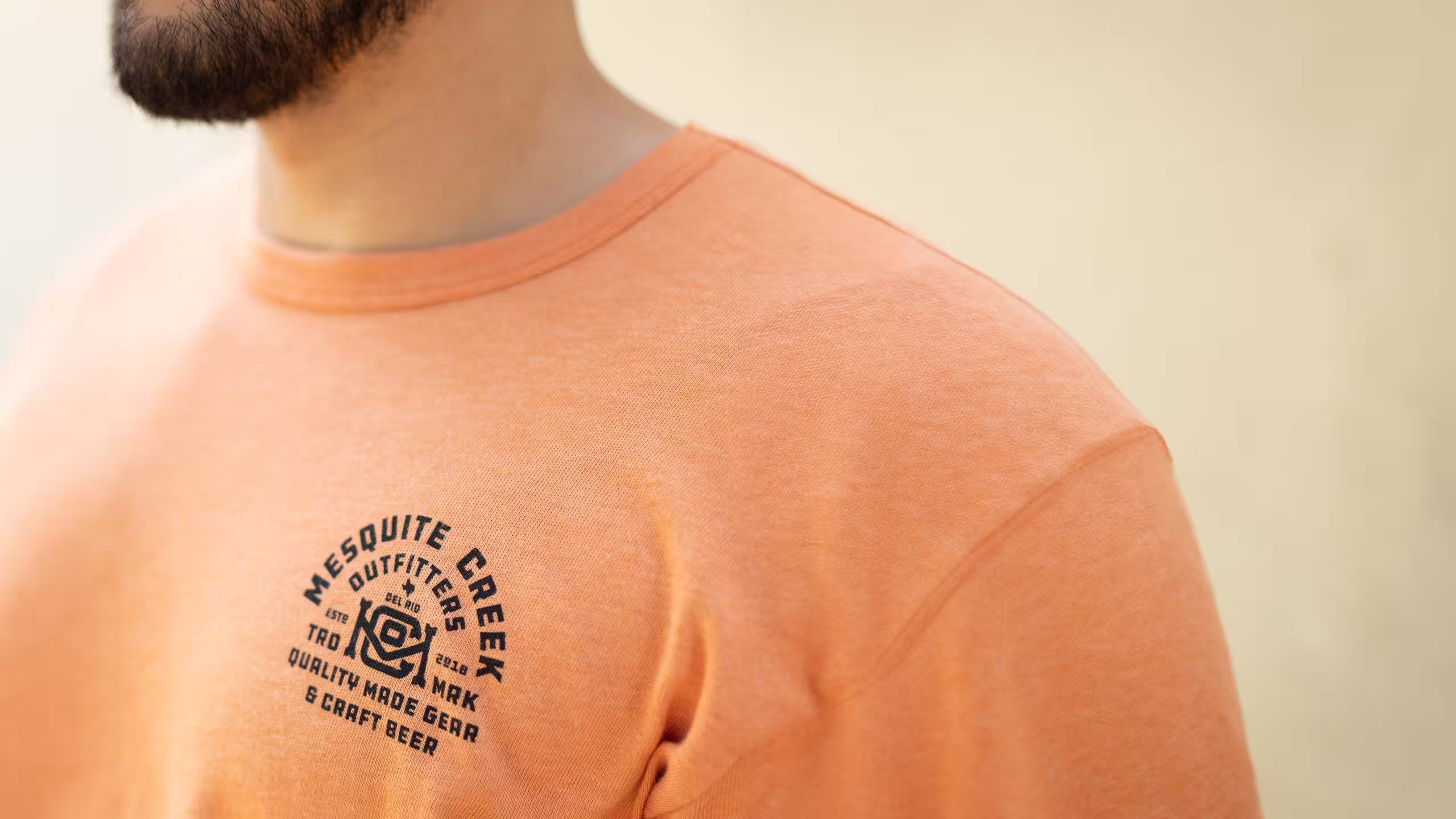 close up of a man wearing a orange t-shirt