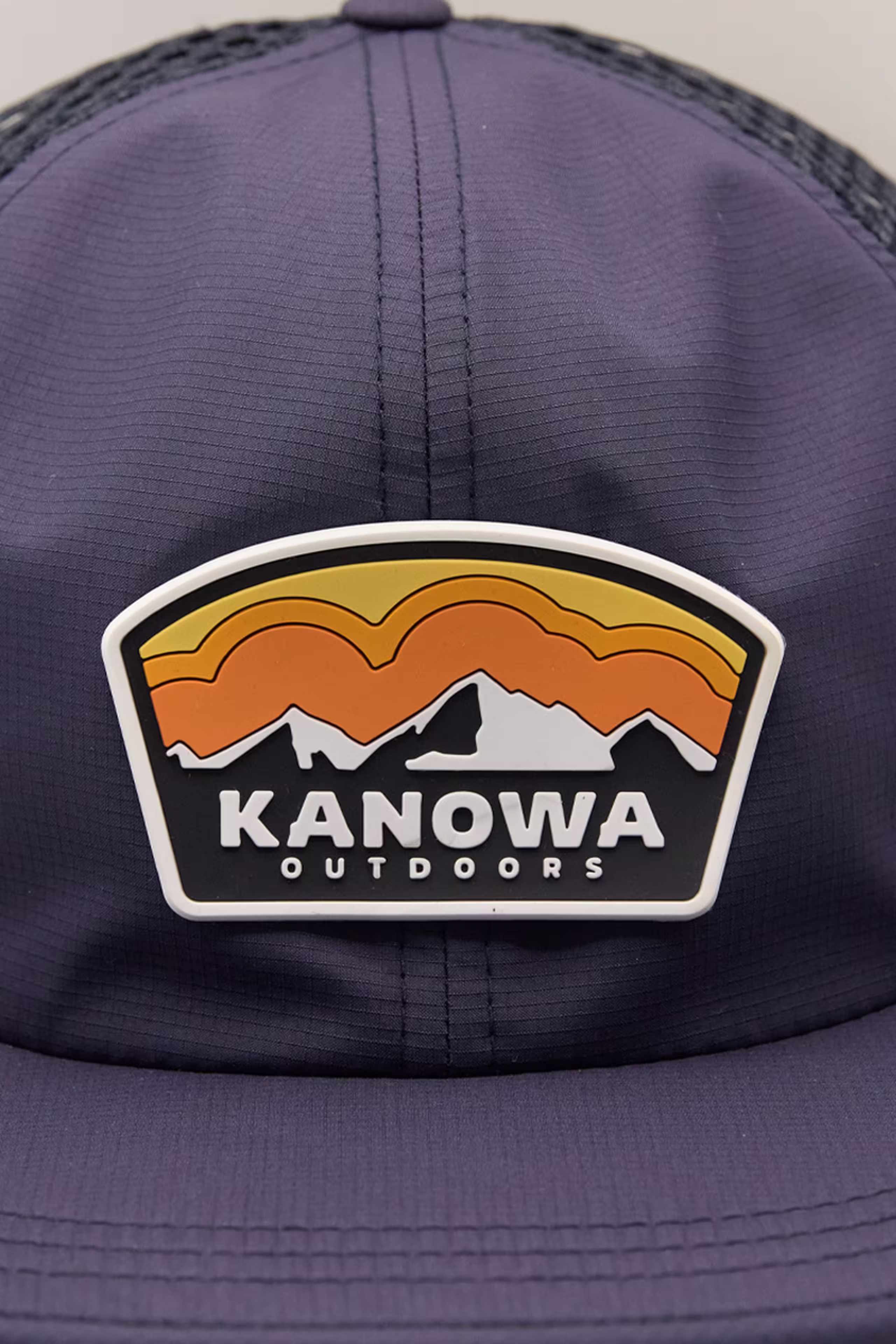a sunset and mountain scape molded patch on a navy hat