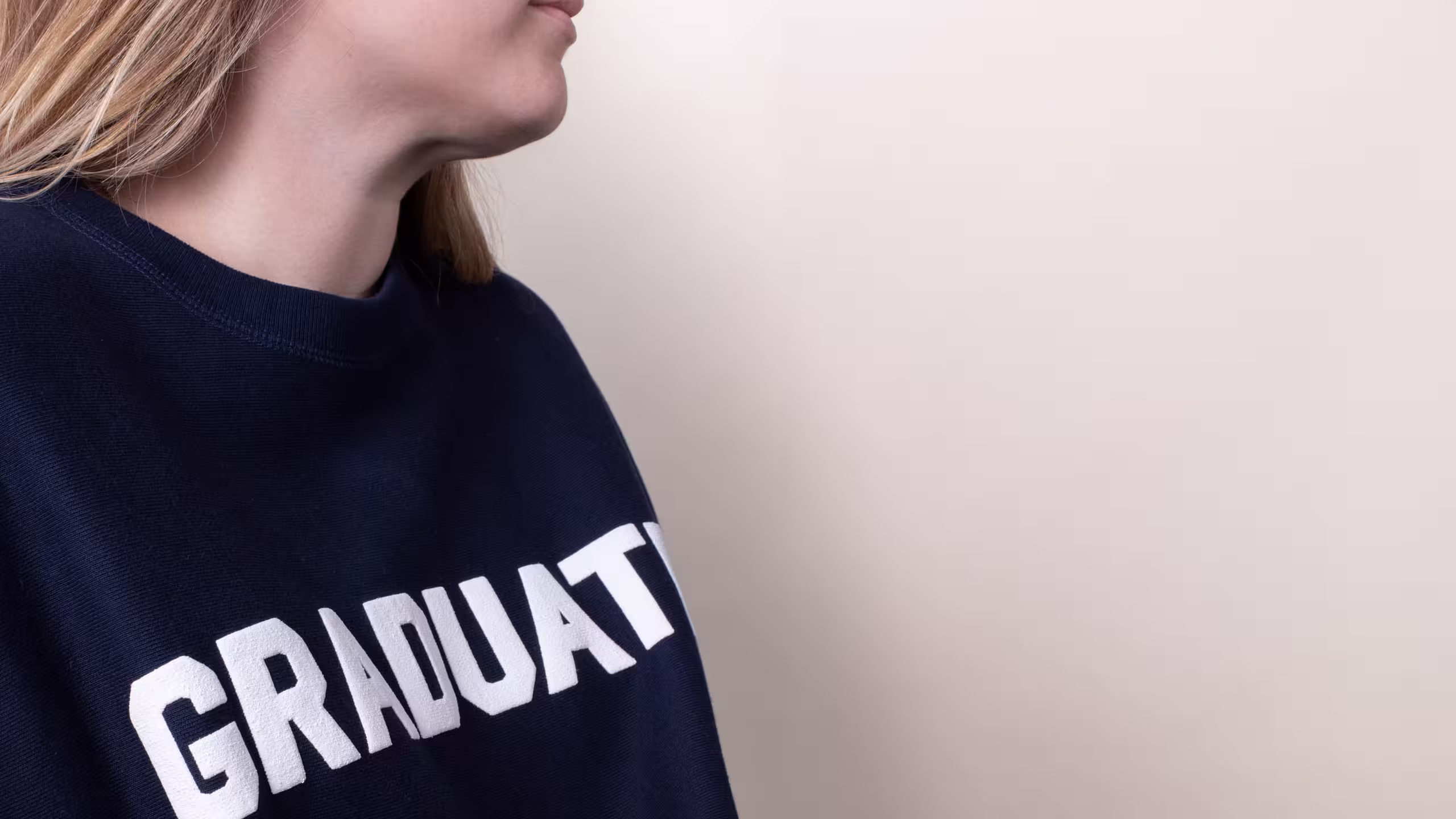 close up of a women wearing a navy crewneck sweatshirt with white puff print