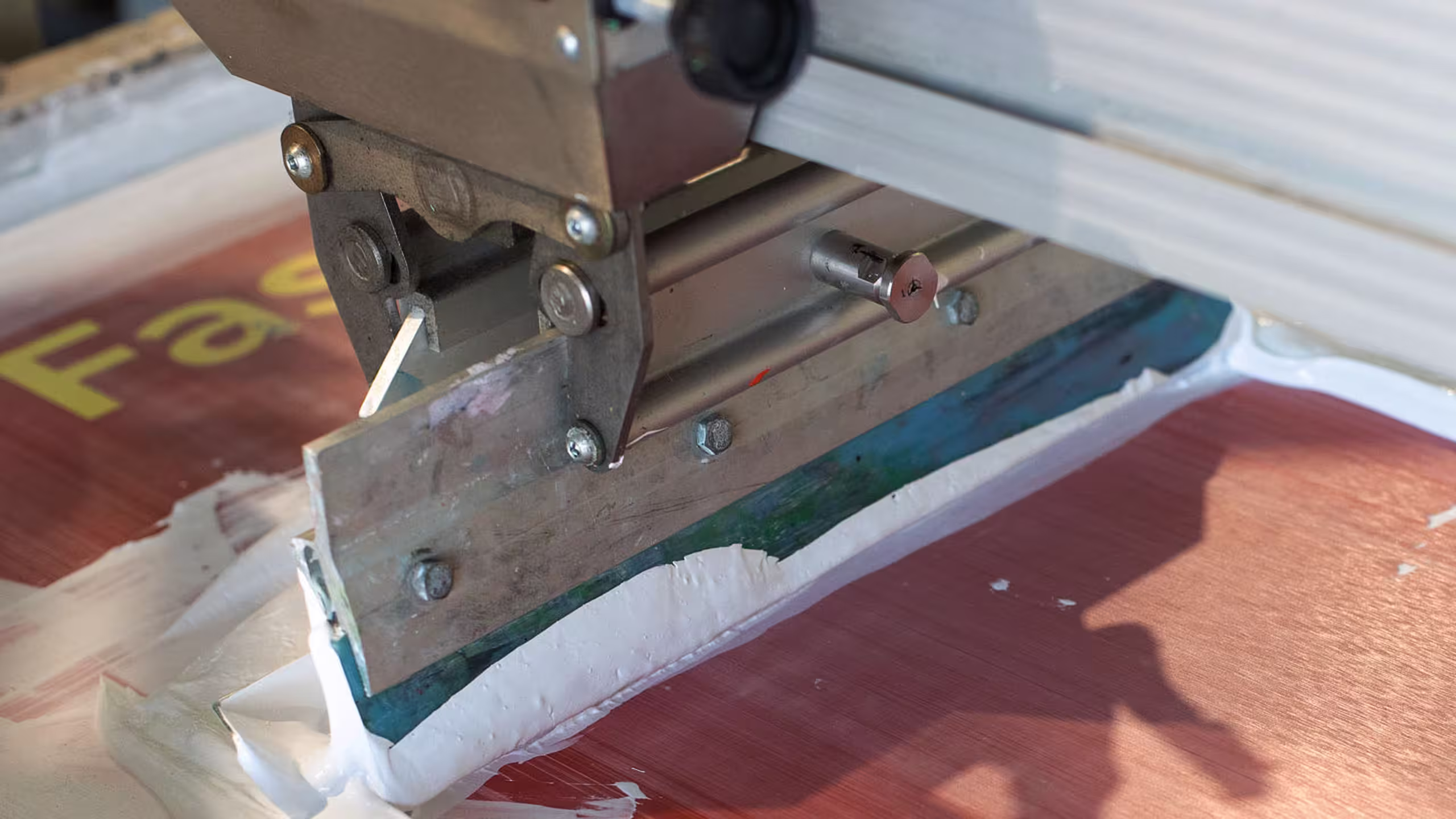 white ink being squeeze on a screen 